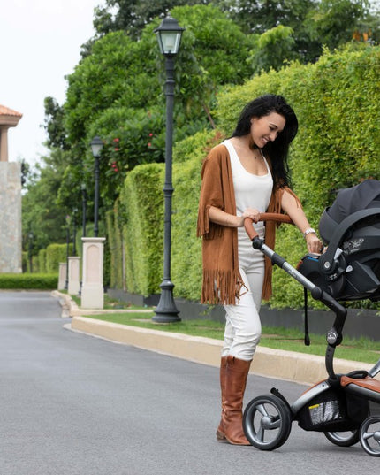 Woman with Mima iZi GO Modular X1 Car Seat on residential street.