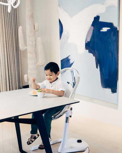 Boy eating in Mima Moon High Chair