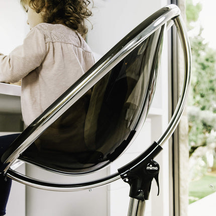 Close-up of a child in a Mima Moon High Chair, focusing on desk activities.