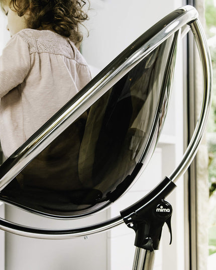 Close-up of a child in a Mima Moon High Chair, focusing on desk activities.