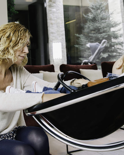 Child enjoying a meal in a Mima Moon High Chair with a purple bib.