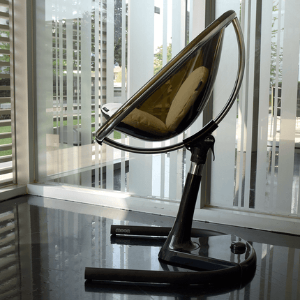 Mima Moon High Chair placed by a modern glass window.