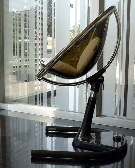 Mima Moon High Chair placed by a modern glass window.