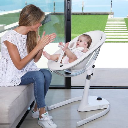 Mother interacting with baby seated in Mima Moon High Chair near a window