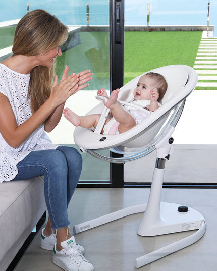 Mother interacting with baby seated in Mima Moon High Chair near a window