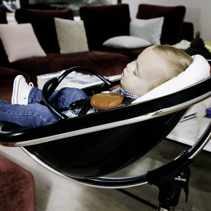 Mother adjusting a Mima Moon High Chair for her sleeping baby.