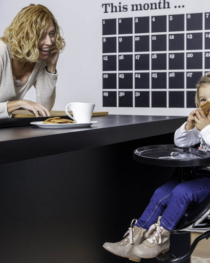 Mother and child interacting over a counter, child sitting in a Mima Moon High Chair.