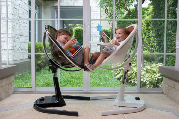 wo children playing in Mima Moon High Chairs by a window