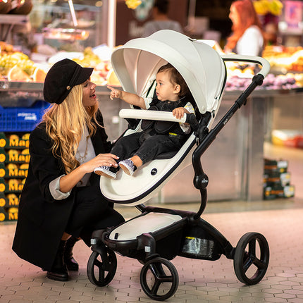 Stylish mother shopping with Mima XARI MAX stroller in a vibrant market