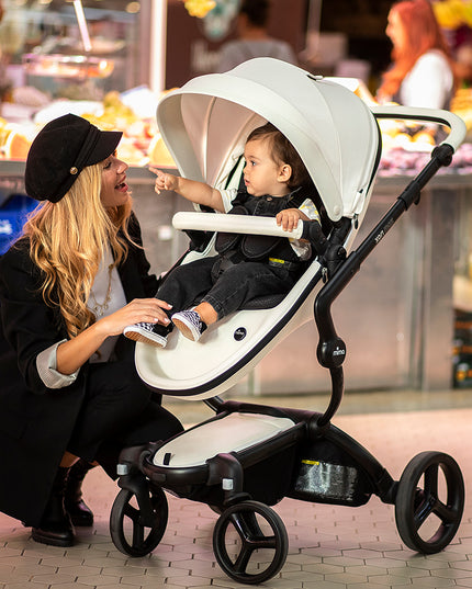 Stylish mother shopping with Mima XARI MAX stroller in a vibrant market