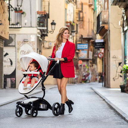 Woman walking with Mima XARI MAX stroller in an urban area