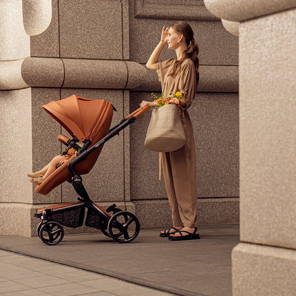 Woman with baby in Mima XARI MAX stroller in an urban area