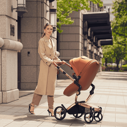 Stylish woman pushing Mima XARI MAX stroller on a city street