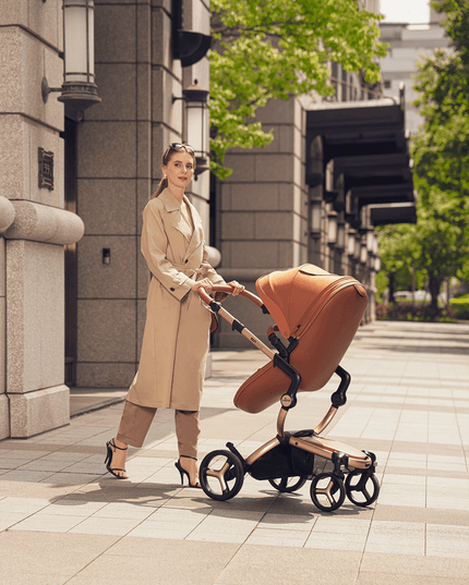 Stylish woman pushing Mima XARI MAX stroller on a city street