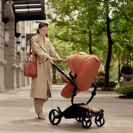 Woman pushing Mima XARI MAX stroller in an urban setting