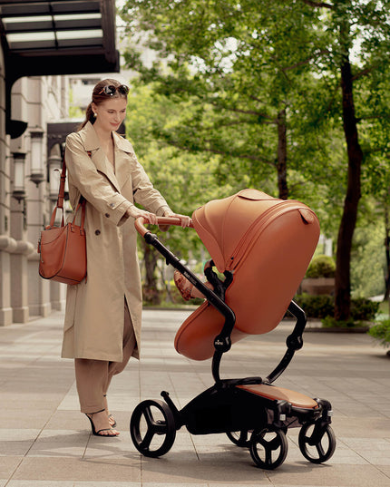 Woman pushing Mima XARI MAX stroller in an urban setting