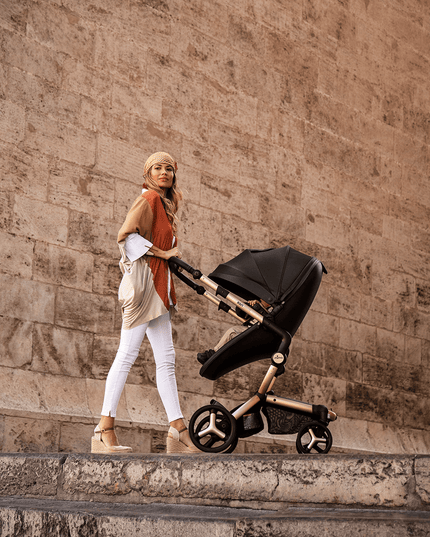 Stylish mother pushing Mima XARI MAX stroller by historical architecture