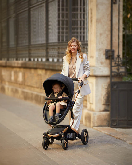 Stylish woman walking with a Mima XARI MAX stroller in an urban setting