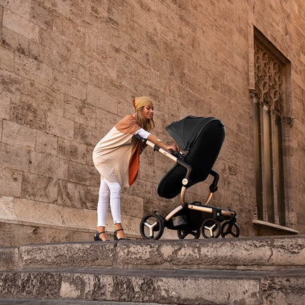 Woman adjusting Mima XARI MAX stroller on steps of historical site