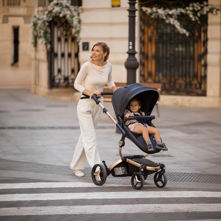 Woman crossing street with Mima XARI MAX stroller and child