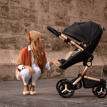 Woman with Mima XARI MAX stroller crouching to interact with child