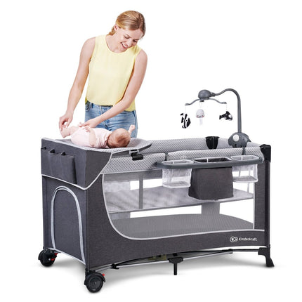 Mother changing baby on Kinderkraft Travel Cot LEODY with changer