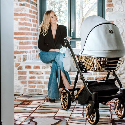 Woman sitting and holding the handle of the Kunert Ivento Glam Stroller 