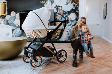 Mother holding her baby next to the Kunert Ivento Glam Stroller